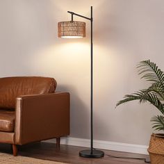 a living room with a brown chair and lamp on the floor next to a potted plant