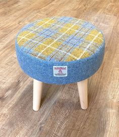 a blue and yellow foot stool sitting on top of a wooden floor