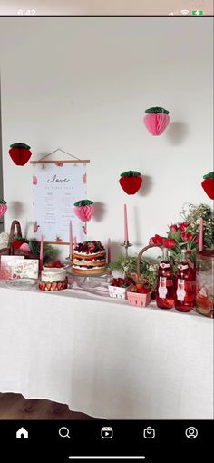 a table topped with cakes and desserts on top of a white cloth covered table