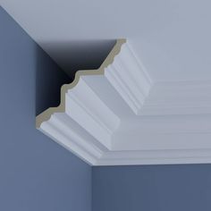 the corner of a ceiling with white moulding and blue walls in an empty room