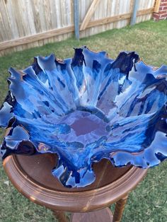 a blue glass bowl sitting on top of a wooden table