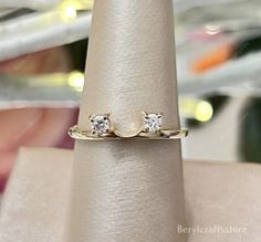 a gold ring with two diamonds on it