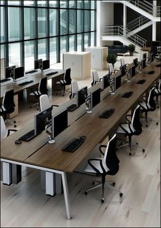 an office with desks and computer screens in the center, along with two chairs