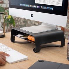 an apple computer sitting on top of a wooden desk