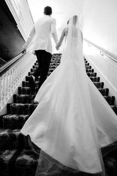 the bride and groom are walking down the stairs