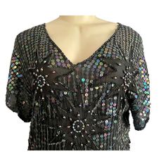 Vintage 70s Sequins Silk Blouse by Sarafino. Made in India, this silk top features a floral aabstract design made with sequins and long beads over a black background.  CONDITION: It's missing some sequins on top of one of the shoulders which is reflected in the price. No size label. Estimated size: L Approx Flat Measurements:  Bust: 40" Waist: 38"  Length: 25" Most of our pieces are pre-loved vintage or antique items. They will sometimes have some wear as they are at least 20 years old. Please examine and zoom in on the photographs as they are part of the description, and let us know if you need more pictures and information. COMBINED SHIPPING: If you are interested in more than 1 item, shipping costs may be lower than shown in your total. Due to the varying weights and sizes of the items, Retro V-neck Party Tops, Festive Black V-neck Top, Black Sequin Disco Top, Black Sequined Disco Top, Retro V-neck Blouse For Party, Vintage V-neck Party Blouse, Vintage V-neck Blouse For Party, Vintage V-neck Blouse For Evening, Fitted Vintage Top For Night Out