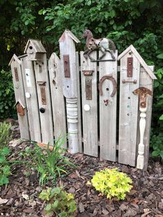 a fence made out of old wooden boards with cats on the top and around it