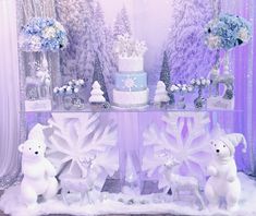 there are two white polar bears standing in front of a table with blue and white decorations