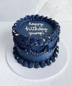 a birthday cake with blue icing and gold decorations on it's top is shown