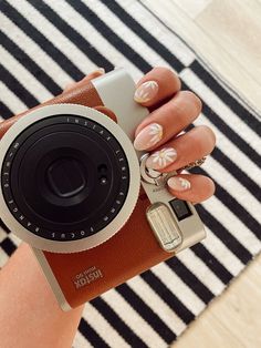 a woman's hand holding an old camera