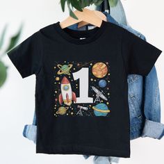 Welcome to Maddy & George Designs! We are excited to present our exclusive collection of baby t-shirts, each meticulously crafted to order. Unlike off-the-shelf products, every t-shirt is individually made with high-quality materials and careful printing techniques to ensure exceptional quality. Since each item is tailor-made for your little one, please allow 3-5 business days for us to prepare your order before shipping. The wait will be well worth it! **Product Information** Our baby t-shirts Short Sleeve Tops With Character Print For Birthday Gift, Crew Neck Top With Cartoon Print For First Birthday, Cotton T-shirt With Character Print For Birthday Gift, Cartoon Print Short Sleeve Tops For Birthday Gift, Cartoon Print Short Sleeve Top For Birthday, Number Print T-shirt For Summer, First Birthday Tops With Cartoon Print And Short Sleeves, Birthday Gift Number Print Short Sleeve Top, Cotton Number Print T-shirt For Birthday