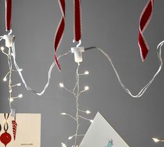 christmas lights are hanging from the ceiling in front of a greeting card and an envelope