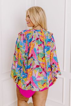 - Grab an umbrella drink and celebrate summer style with this vibrant top! Effortlessly stylish and exuding a playful charm, this top invites you to indulge in vibrant vibes wherever you go. - Unlined material with a pink, purple, yellow, orange, blue, and green hued botanical print - A v-cut neckline with a tie detail and a ruffled back - Long sleeves with smocked cuffs - A relaxed silhouette that ends in a straight hemline Purple Yellow Orange, Short One Piece, Leopard Dress, Black Dresses Casual, Little White Dresses, Crop Top Blouse, Curve Dresses, Short Leggings, Botanical Print