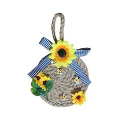 a small basket with sunflowers and bees on it's side, hanging from a rope