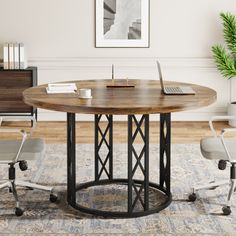 a round table with two chairs and a laptop on it in the middle of a room