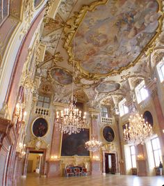 an ornate room with chandeliers and paintings on the walls