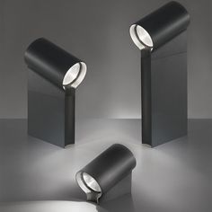 three black lamps with one light on each side and the other in the middle, against a gray background