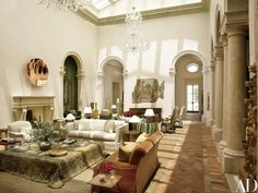 a living room filled with lots of furniture next to a fire place in a building