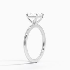 a white gold ring with a princess cut diamond in the center, on a white background