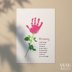 a card with a pink flower and the words mommy written in red ink on it