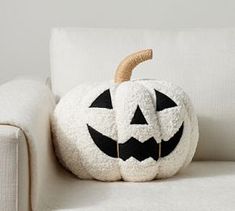 a white couch with a black jack - o'- lantern pillow on top of it