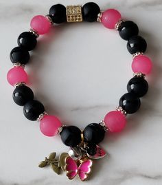 made with durable stretch cord pink glass black onyx is a valuable stone that provides strength Pink Jewelry With Adjustable Black Beads, Black Adjustable Stretch Bracelet With Gemstone Beads, Adjustable Pink Stretch Bracelet With Gemstone Beads, Adjustable Pink Gemstone Bead Stretch Bracelet, Onyx Beaded Stretch Bracelet Gift, Adjustable Black Onyx Bead Stretch Bracelet, Hand-strung Adjustable Onyx Stretch Bracelet, Adjustable Onyx Stretch Bracelet With Black Beads, Adjustable Onyx Stretch Bracelet With Gemstone Beads