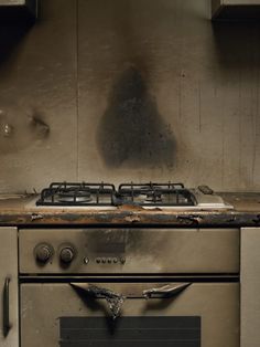 a dirty stove top oven sitting in a kitchen