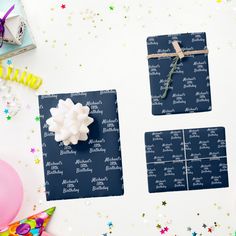 two pieces of blue and white paper on a table with balloons, confetti and streamers