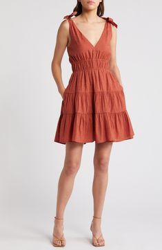 A tiered, ruffled skirt adds playful flounce to this smocked-waist minidress punctuated with ties at each shoulder. 35" length (size Medium) Slips on over head V-neck Side-seam pockets Lined 61% rayon, 27% polyester, 12% nylon Machine wash, line dry Imported Fitted Tiered Mini Dress With Smocked Back, Fitted Mini Dress With Smocked Back And Tiered Design, Pleated Mini Sundress, Pleated Mini Length Sundress, Smocked Bodice Fit And Flare Mini Dress, Flirty Tiered Mini Dress With Smocked Bodice, Ruffled Tiered Skirt Sundress, Spring Mini Ruffle Dress With Smocked Bodice, Casual Ruffle Dress With Smocked Bodice