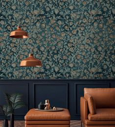 a living room with two leather chairs and a footstool in front of a blue wall