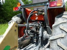 the front end of a tractor parked on gravel