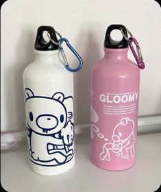 two water bottles sitting next to each other on a counter with a keychain