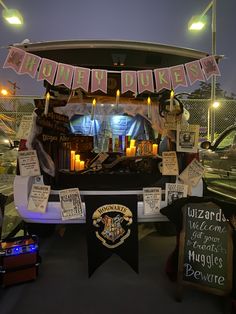 a display with candles and signs in front of a car at night time that says harry potter