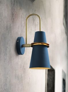 a wall light with a blue shade hanging from it's side on the wall