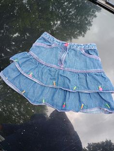 Vintage Y2K (2004) Gymboree little girl ruffled and tiered blue jean skirt. Features colorful embroidered veggies and girly pink stitching. Pockets at the hips. Zipper and button fly. 100% cotton.  Approximately 12 inches long. Cute Blue Cotton Denim Skirt, Cute Blue Denim Skirt, Cute Blue Tiered Skirt Bottoms, Cute Blue Tiered Skirt, Custom Jean Skirt, Custom Jean, 2000s Party, Girl Y2k, Blue Jean Skirt