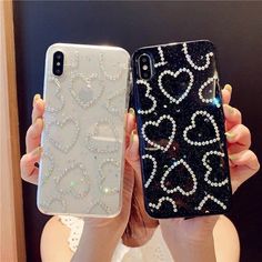 two women holding up their cell phones in front of them with hearts and diamonds on them