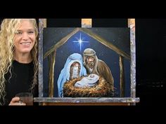 a woman standing next to a painting of the birth of jesus