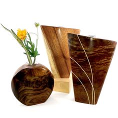 three wooden vases with flowers in them