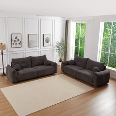 a living room with two couches and a rug in front of the large window