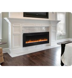 a living room with a fireplace and white furniture in the corner, along with a flat screen tv mounted on the wall