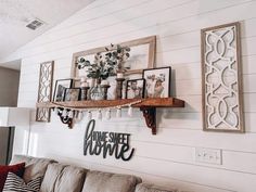 a living room filled with furniture and pictures hanging on the wall above it's shelves