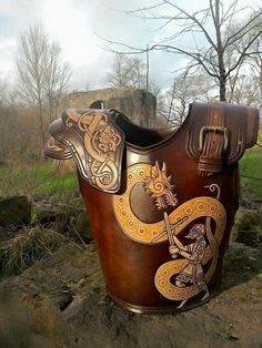 a large wooden horse saddle sitting on top of a field