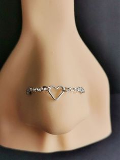 a close up of a mannequin head with a heart shaped bracelet on it