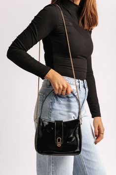 The Paige Black Vegan Leather Shoulder Crossbody Bag combines style with functionality, crafted from sleek patent vegan leather for a modern, polished look! It features a versatile design with a magnetic snap closure, ensuring easy access while keeping your belongings secure. The gold hardware adds a touch of luxury, complementing the bag's glossy finish. Equipped with a detachable chain strap, it can be worn as a shoulder bag or crossbody, offering flexible styling options. Inside, the fabric-lined interior includes a zip pocket for keeping essentials organized and within reach. Chic Everyday Bag With Glossy Finish, Chic Glossy Shoulder Bag For Everyday Use, Chic Glossy Finish Shoulder Bag, Glossy Finish Shoulder Bag For Party, Trendy Shoulder Bag With Glossy Finish For Everyday, Trendy Glossy Shoulder Bag For Everyday Use, Trendy Glossy Finish Shoulder Bag For Everyday Use, Chic Glossy Crossbody Shoulder Bag, Chic Glossy Crossbody Bag