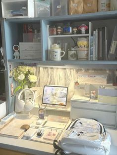 a desk with a computer, printer and other office supplies on it's shelves