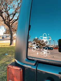 the side mirror of a car that has flowers on it and stars in the sky