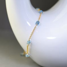 Delicate single strand bracelet created with gemstones in pretty blue color. This bracelet is made with dainty gold filled chain adorned with duos of small, faceted roundels of  London blue topaz. Gems are wrapped with gold filled wire and separated with short sections of dainty,  gold filled chain.  Adjustable from 7.5 to 8.5 inches and it closes with a gold filled lobster claw clasp. Elegant, dainty, trendy, great for layering, bracelet for any occasion. It will make a sweet gift. This style i Blue Beaded Bracelets With Birthstone, Blue Birthstone Beaded Bracelets, Blue Birthstone Round Bead Bracelets, Blue Birthstone Bracelets With Round Beads, Dainty Blue Gemstone Beaded Bracelets, Blue Dainty Gemstone Beaded Bracelet, Blue Dainty Birthstone Bracelets, Dainty Blue Gemstone Bracelets, Dainty Blue Gemstone Bracelet