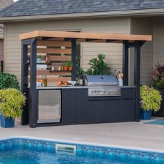 an outdoor bbq grill next to a swimming pool with potted plants on either side