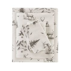 two napkins with deer and pine trees on them, one is folded to the side