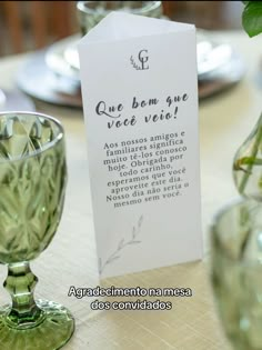 there is a table setting with flowers in vases and a card on the table